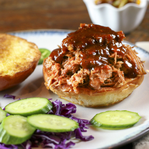 This recipe is a slow-cooker version of Sweet and Sriracha Spicy Oven Roast Pulled Pork by White on Rice Couple. Use this pulled pork to make delicious sandwiches or spicy tacos.